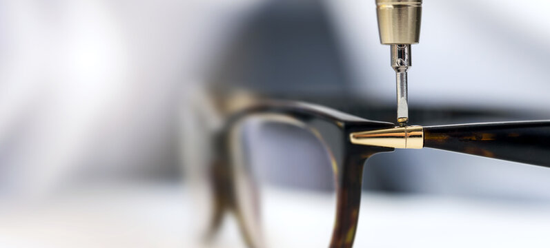 eyewear repair service - screwing the screw in eyeglass frame. copy space