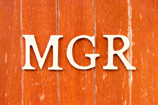 Alphabet letter in word mgr (abbreviation of manager) on old red color wood plate background