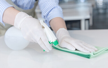 Close up Staff hand Restaurant workers are cleaning table and spraying disinfectants during the virus outbreak, Using cleaning solutions or using alcohol to kill germs in the restaurant.