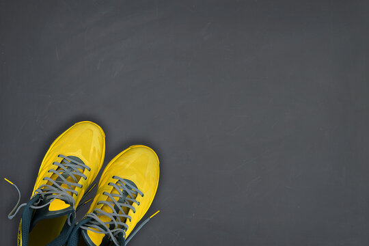 Yellow sneakers on grey background. Trending colors of 2021. Minimal concept.