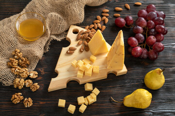 Cheese, pears and nuts on a wooden cutting board