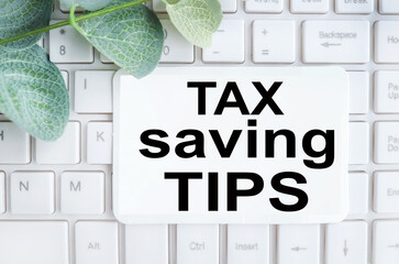 TAX SAVING TIPS. text on white paper on white keyboard