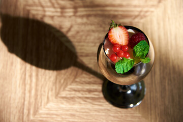 dessert in a glass, top view, strawberries, raspberries, mint and viburnum berries