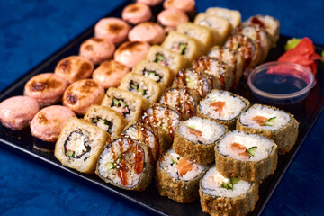 japanese rolls, sushi with sauce on a blue background
