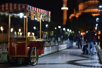 Traditional cart of Turkish street food in night near with Blue Mosque. Text on signboards in...