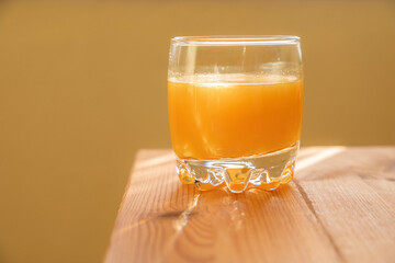A delicious homemade orange juice, freshly squeezed in the morning, healthy and full of vitamins, rests in the glass by the window before breakfast. Vegetarian drink for a healthy diet.