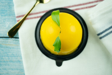A piece of jelly orange cake with green leaf serving on plastic cup