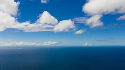 Naklejka na ściany i meble Aerial seascape of Blue sea and sky with clouds. Summer and travel vacation concept. Flight over the sea.