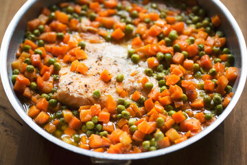 Fried salmon fish with carrot and peas 