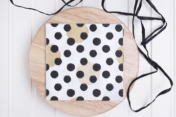 Serwetka w czarne kropki na drewnianej desce © Seance_Photo_Sylwia