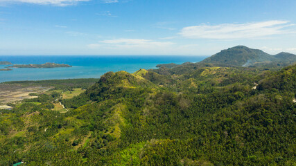 Obraz premium The mountains and hills with tropical forest with blue sea. Tropical landscape, Mindanao, Philippines.