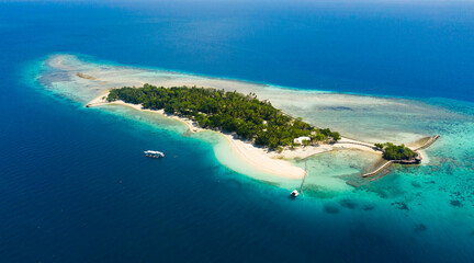 Little Liguid Island with a sandy beach and azure water surrounded by a coral reef and an atoll, aerial view. Little Cruz Island, Philippines, Samal.