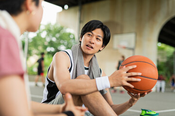Naklejka premium バスケの練習中に休憩をとる男女