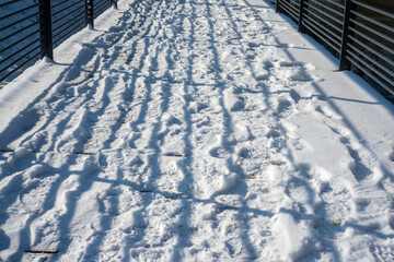 Footsteps in the snow, striped shadows