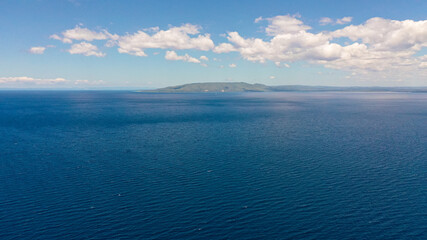 A erial seascape of Cebu island and blue sea against the sky with clouds.