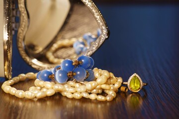 Jewelry box and necklace on a dark colored background.
