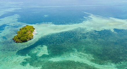 Drone view of a tropical island with palm trees and a beach in the turquoise waters of a coral reef. Panglao, Philippines.