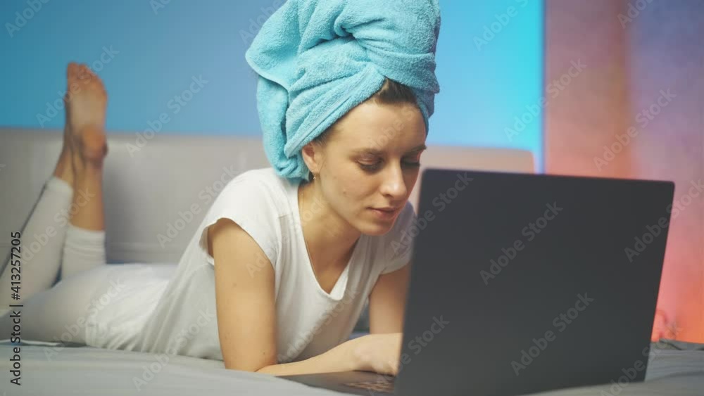 Poster a attractive smiling woman is typing text message and using laptop while at home. the beautiful girl