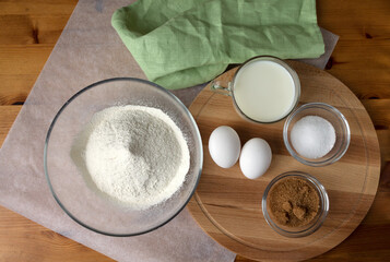 The necessary set of ingredients for making pancakes and pancakes eggs flour salt sugar and milk.