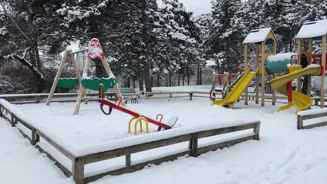 Empty children's playground covered with snow in winter