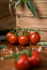 Red cherry tomatoes in a food photography scene with wood basket and details in background
