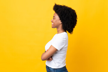 Young African American woman isolated on yellow background in lateral position