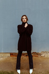 Caucasian woman, model, posing and looking at the camera, with an street underground wall in the...