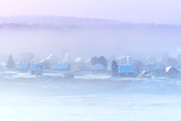 Winter landscape. Russian village with old wooden traditional Russian style. Roofs covered by snow...