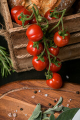 Red cherry tomatoes in a food photography scene with wood basket and details in background