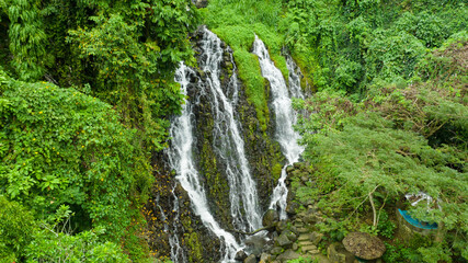 Fototapeta na wymiar Waterfall in the green forest. Mimbalut Falls in the jungle, island of Mindanao, Philippines. Iligan City, Lanao del Norte.