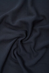 Pleats on fabric, knitted material of dark blue color, folds
