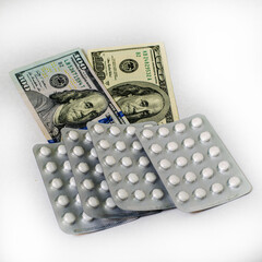 concept pharmaceutical business blisters with pills are on hundred dollar bills