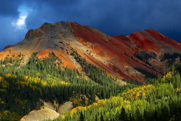 Red Mountain Pass with autumn foliage and yellow aspen leaves on a stormy afternoon in the Colorado...