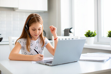 Fototapeta na wymiar Photo of a pupil doing her homework under the guidance of an online teacher.