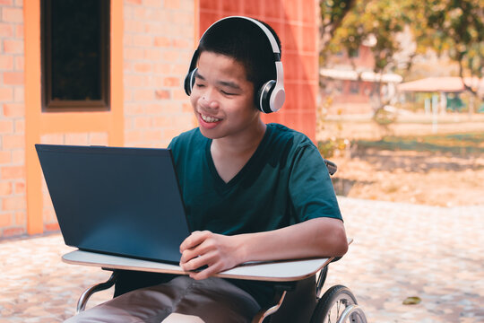 Special need child on wheelchair use a tablet in the house with his parent, Study or Work at home for safety from covid 19, Life in new normal education of special need kid,Happy disabled boy concept.