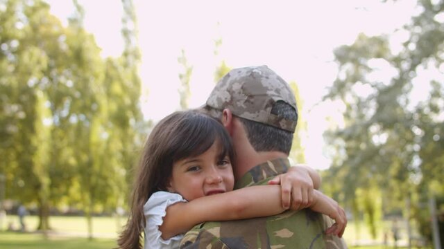 Military Dad Carrying Daughter In Arms, Walking In Park, Spending Time With Kid After Returning Home. Dolly Shot. Soldier Father Or Fatherhood Concept