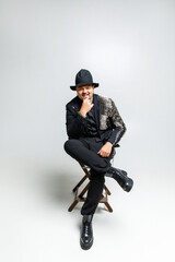 portrait of a brutal man in black clothes on a white background