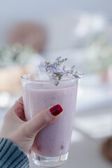 Tall Glass Of A Thick Pink Smoothie held in hand 