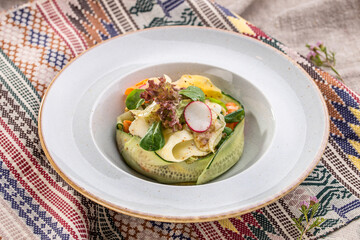 Plate of healthy green garden salad with cucumber, carrot and radish on the table