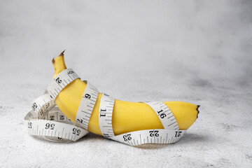 Banana spun with measuring tape - Healthy food and weight management concept