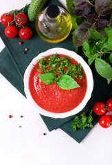 Tomato gazpacho soup in ceramic bowl topped with basil leaves. Spanish cuisine cold soup