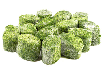 Frozen briquettes of spinach leaves on a white plate.