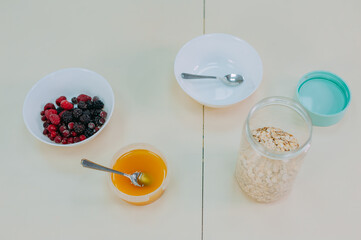 Oatmeal with fruit in a glass on a table with honey.