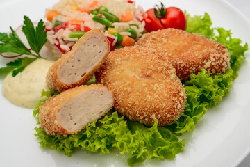 Chicken cutlets in batter with risotto and vegetables