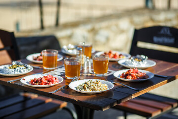 Plates with food on a wooden table on a summer terrace in a cafe