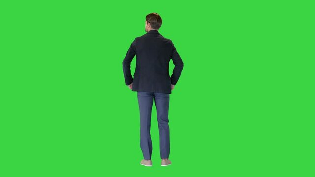 Confident businessman standing with hands on hips looking around on a Green Screen, Chroma Key.