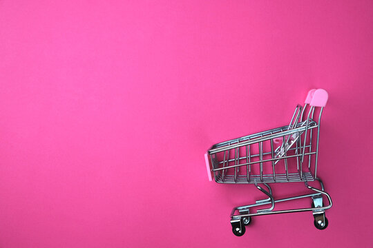 Shopping Cart On A Pink Background. View From Above. Sales Concept. Banner With Copy Space. 