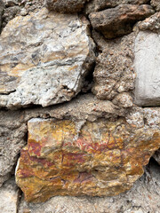 Old rock wall closeup including red and gold rocks