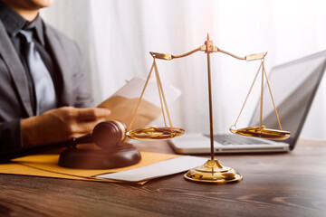 Justice and law concept.Male judge in a courtroom with the gavel, working with, computer and...
