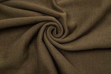 Pleats on fabric, knitted material of khaki color, folds